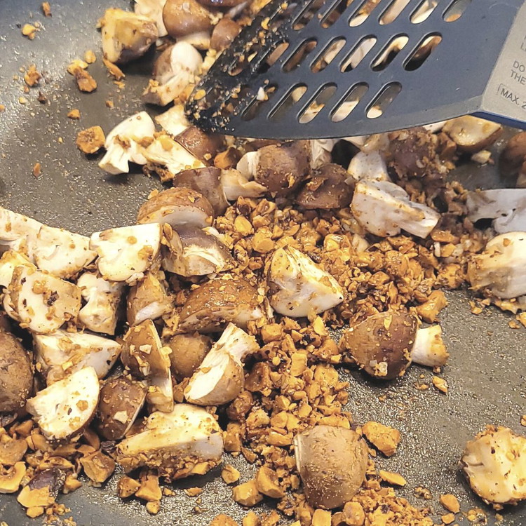 Image of Die gehackten Haselnüsse, die Champignons ca. 2 Minuten anbraten. Den gehackten Knoblauch hinzu fügen, umrühren und mit dem Weisswein ablöschen