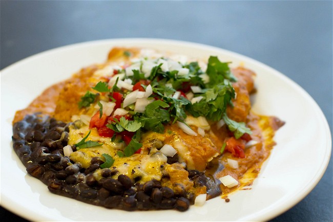 Image of Enchiladas suizas (tortillas filled with cheese, topped with creamy green sauce and baked)