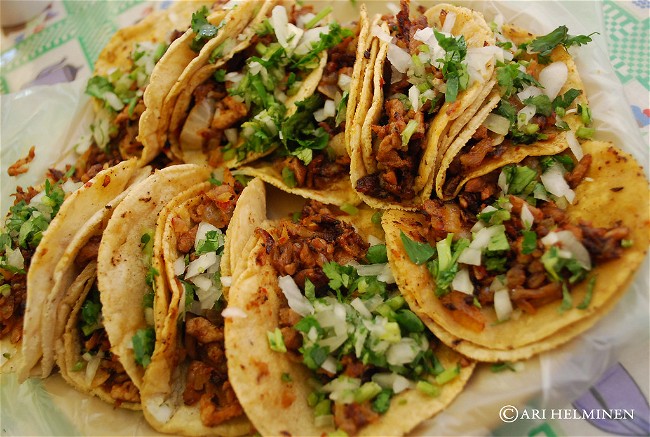 Image of Tacos al pastor (tacos filled with marinated pork cooked on a vertical spit)