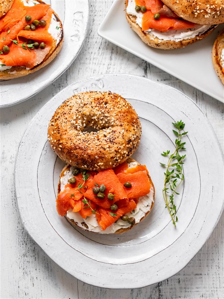 Image of Spread cream cheese on each bagel bottom and top with...