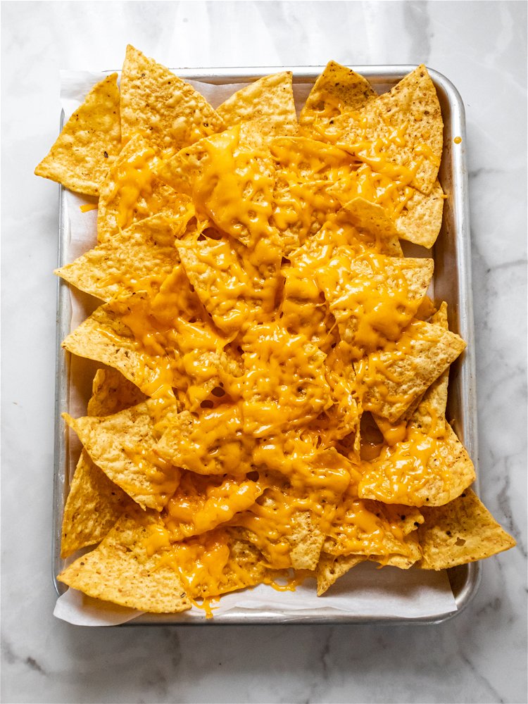 Image of While shrimp cooks, spread tortilla chips on a parchment paper...