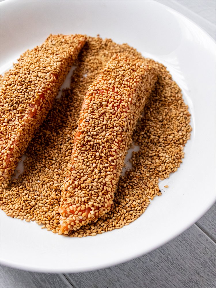 Image of While pan heats coat salmon on all sides with sesame...