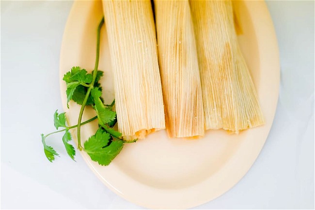 Image of Tamales (corn dough filled with meat or vegetables, wrapped in corn husks)