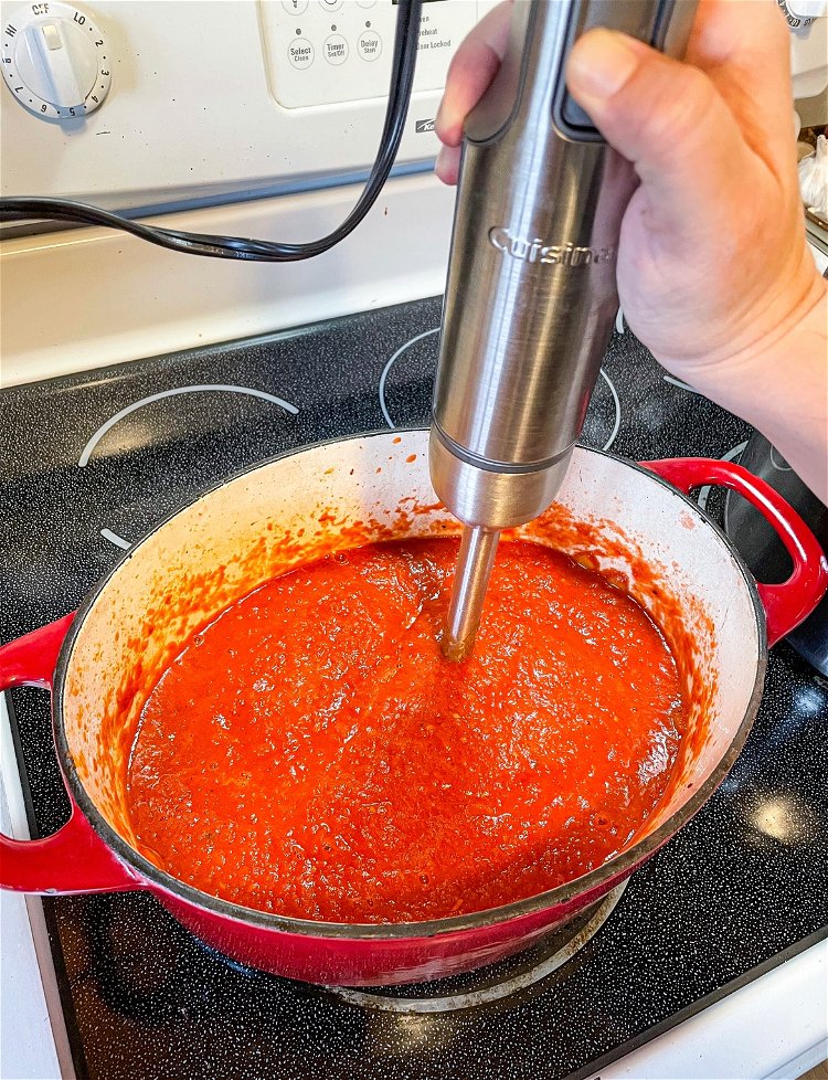 Image of Pour in your canned tomatoes. With an immersion blender, blend...