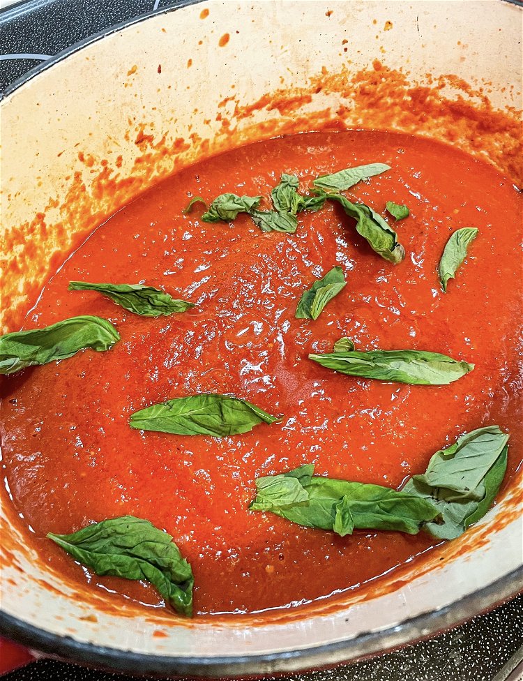 Image of Add your sugar and basil leaves to the sauce and...