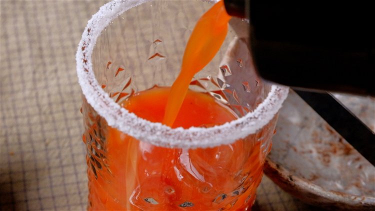 Image of Den Drink in ein mit Eiswürfeln gefülltes Glas geben.