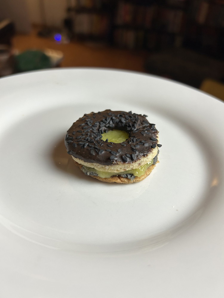 Image of On the bottom cookies, spread the black sesame frosting on the bottom cookies, and spread the mango curd on top of that. Place the top cookie on top to make a “sandwich.”