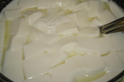 Image of Allow the curds to sit undisturbed for 15 minutes until set to the consistency of soft jello. Use a long knife that reaches to the bottom of the pot and cut a 1