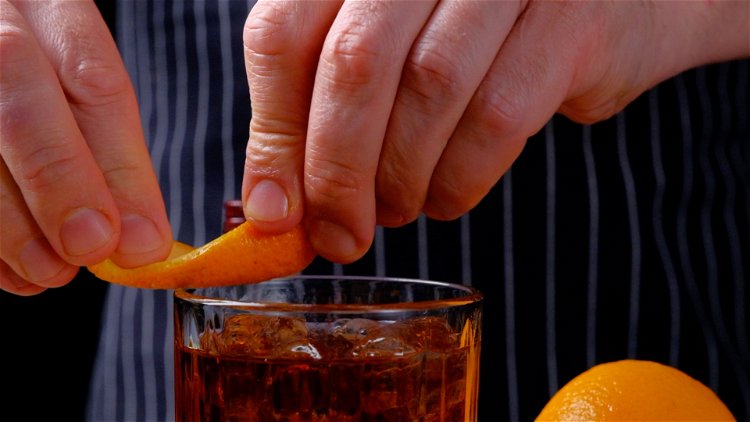 Image of Der Drink wird abschließend mit der Orangenzeste abgespritzt und garniert.