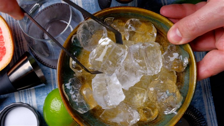 Image of Zunächst werden die Eiswürfel in ein Glas gegeben.