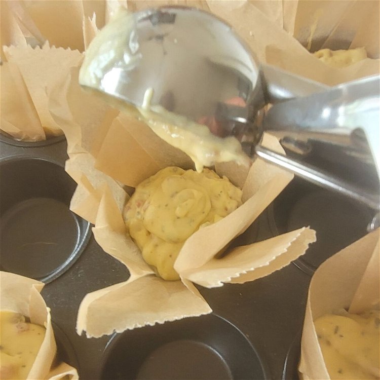 Image of Mithilfe eines Eisportionierers dein Teig in die vorbereitet Muffinform abfüllen