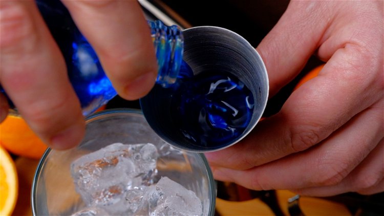 Image of Zunächst den Wodka und Blue Curaçao über einige Eiswürfel in...