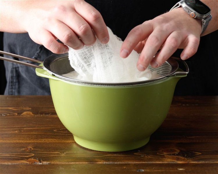 Image of Pour the yogurt mixture into the cheesecloth. Fold the cloth...