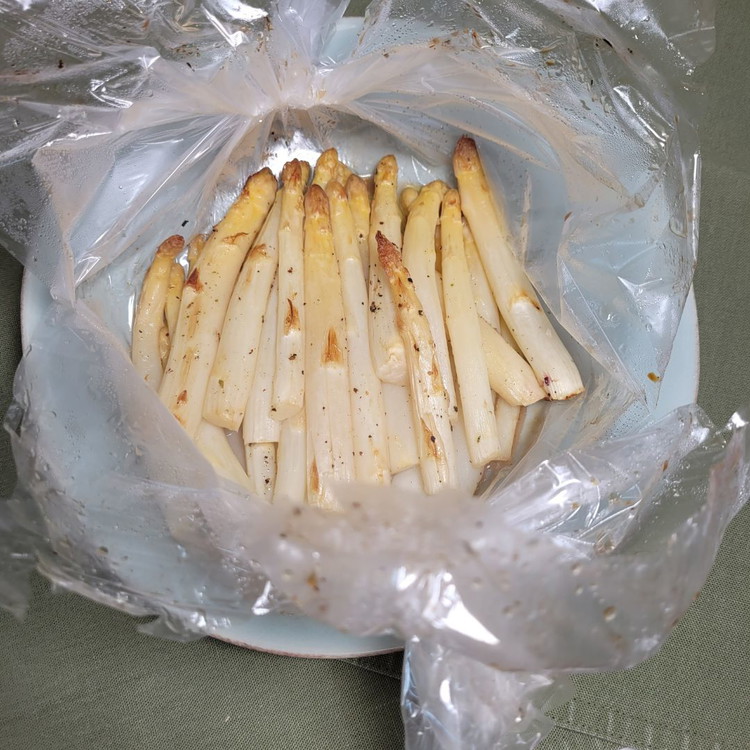 Image of Den gegarten Spargel auf einen Teller legen und mit der Schere den “Ballon” oben aufschneiden. Vorsicht es tritt heisser Dampf aus! Du siehst, der Spargel hat eine wunderbare Bräunung angenommen. Da sind die traumhaft feinen Röstaromen versteckt.