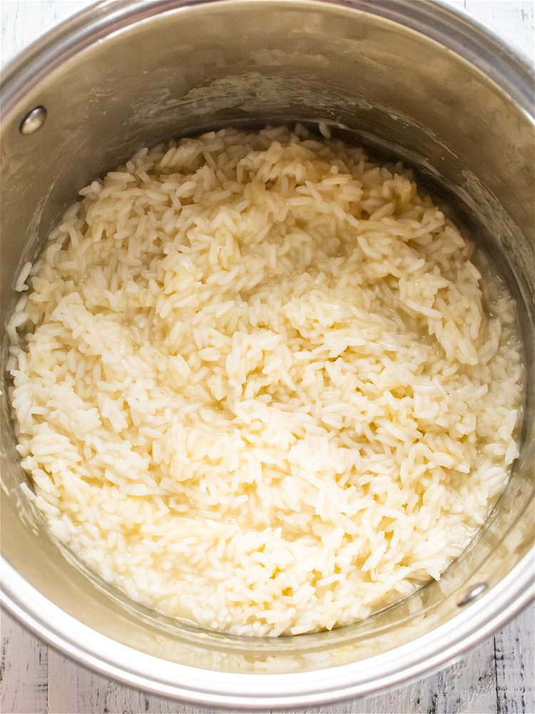 Image of Combine rice and chicken stock in a medium saucepan over...
