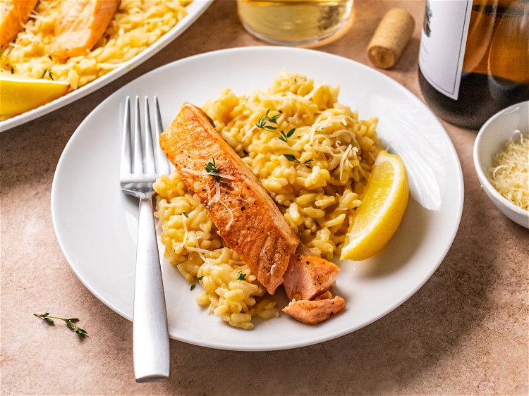 Image of Serve salmon over risotto with lemon wedges, extra thyme and...