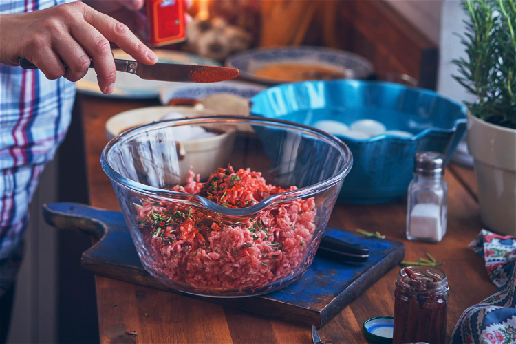 Image of Squeeze the pork sausage meat out of its sausage covering...