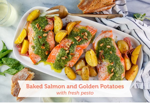 Roasted Salmon with pesto and potatoes on a white serving platter.