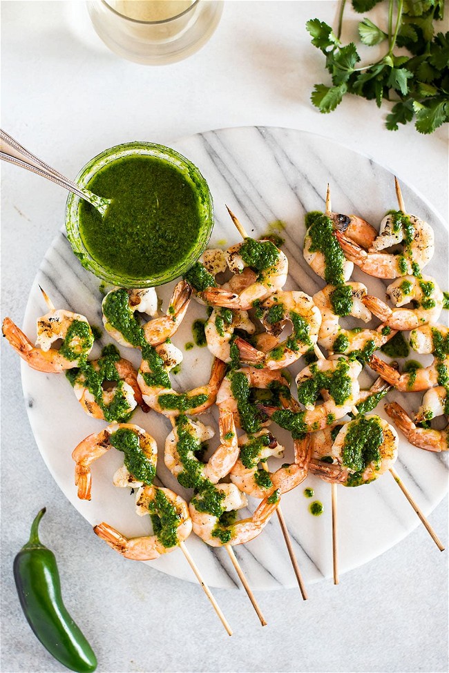 Image of Simple grilled shrimp skewers drizzled with homemade chimichurri sauce