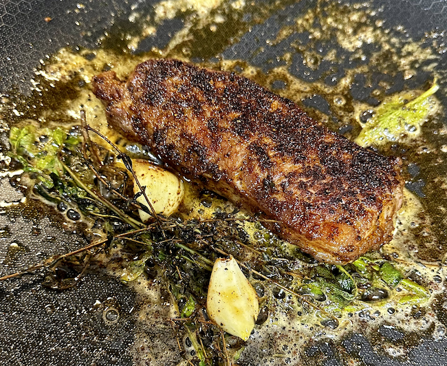 Image of After searing both sides for about a minute, add in the butter, garlic and herbs. Baste the steaks while they cook for another 5 min. These steaks don't take long to cook, so cook for only 7-9 minutes total depending...