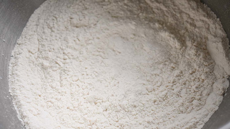 Image of In a large mixing bowl, sift together sugar, baking powder, salt and flour.