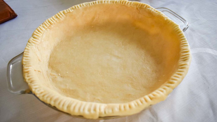 Image of Preheat the oven to 400° and line a 9-inch deep pie pan with pie crust and set aside.