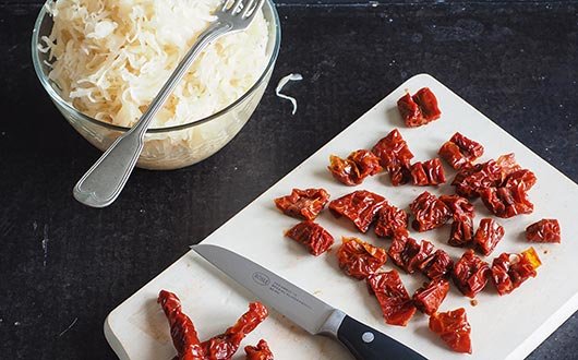 Image of Weiter mit dem Kartoffel-Gulasch: Sauerkraut auflockern, Soft-Tomaten quer in 1...