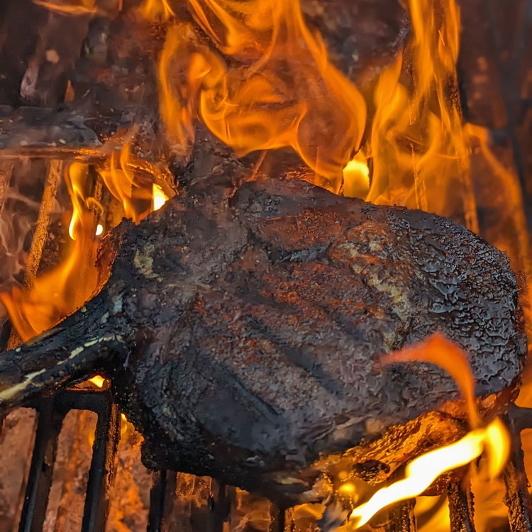 Image of Sear the steak directly in the fire for 30 seconds a side, making sure to also sear a bit on the edges where the fat cap is.