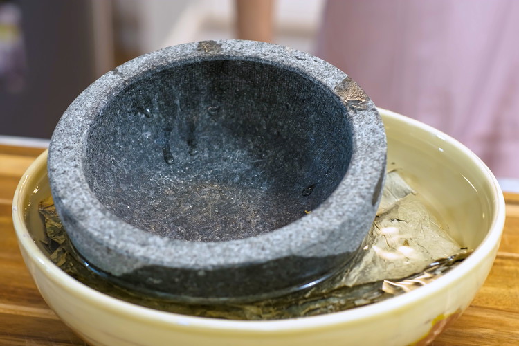 Image of Soak the lotus leaves for 2 hours or until they are soft and pliable. The leaves are big; you may have to fold them and use something heavy to press them down under the water.
