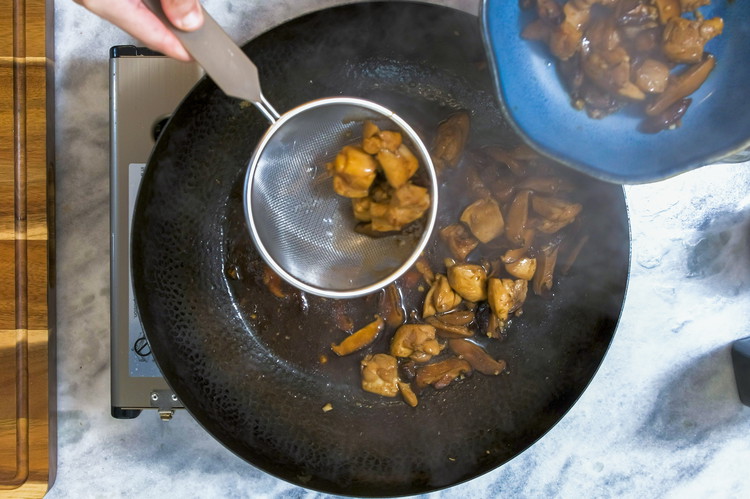 Image of Use a strainer to take the chicken and the mushroom out, leaving the soup behind.