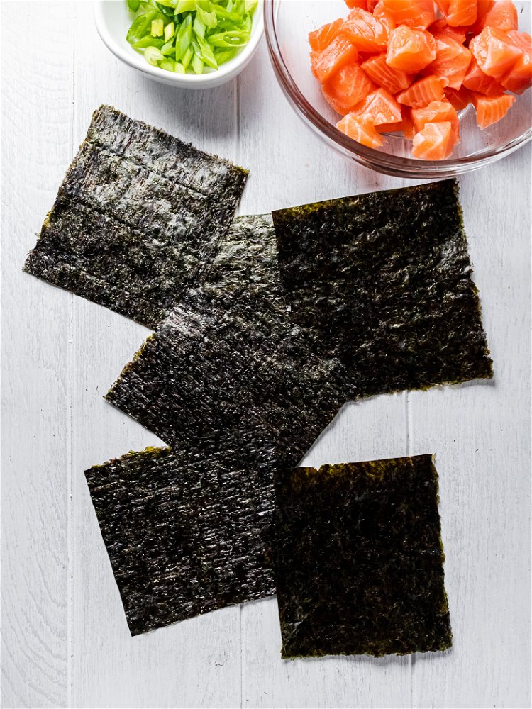 Image of Cut nori sheets to create 4 equal squares (you will...