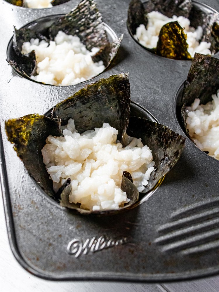 Image of Spoon 2 tablespoons of rice onto center of nori squares...