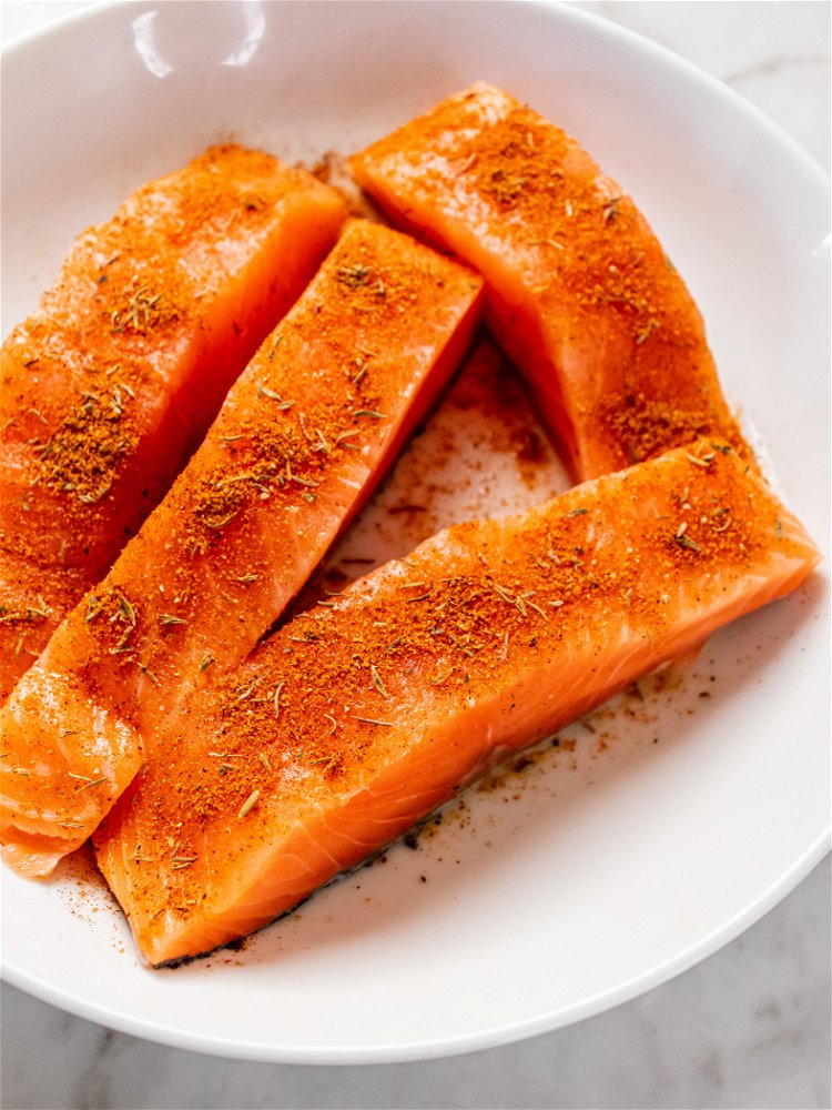 Image of Blot salmon with paper towel and season flesh with 1...