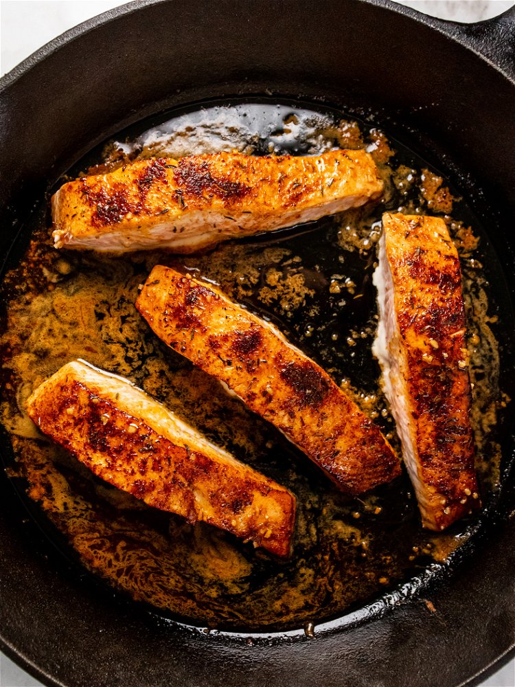 Image of Pour sauce into skillet over salmon and transfer to oven....