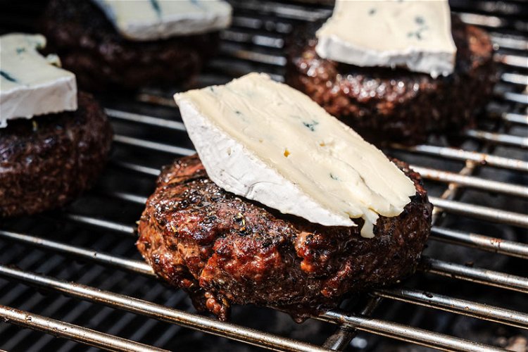 Image of Top the burgers with a blue cheese slice during the...