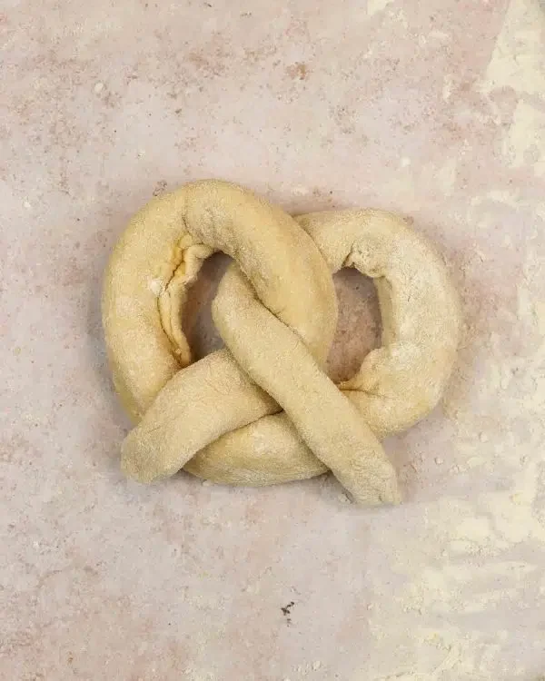 Image of Create a U-shape with the stuffed pretzel dough, then twist...