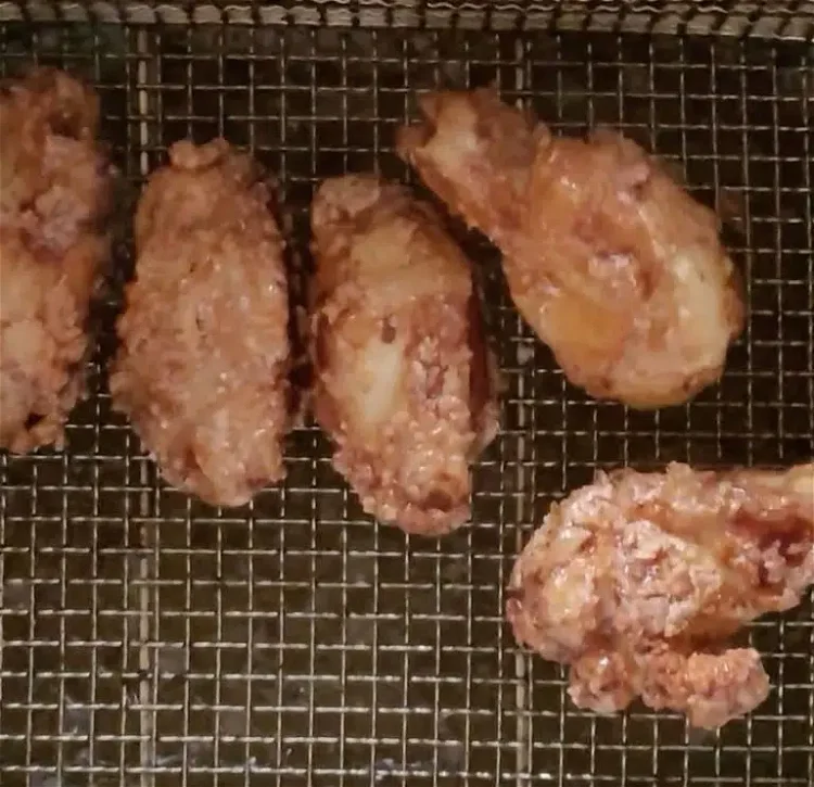 Image of Drain chicken wings on paper towel, add to bowl and toss with 1/2 cup Melinda’s Thai Sweet Chili sauce.