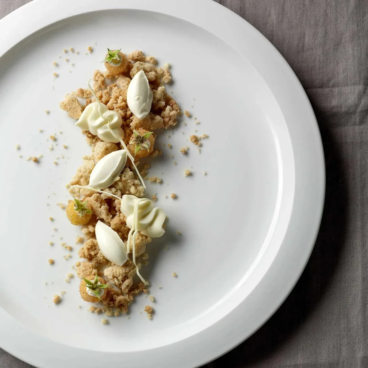 Dessert mit weißer Schokolade, weißen Himbeeren und Mandelstreuseln