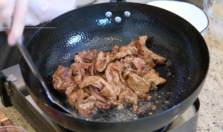 Image of Heat the wok until smoking hot and add a generous amount of oil. Swirl the oil around to create a non-stick layer. Add the beef and spread it out. The heat is on high, so you only need to cook...