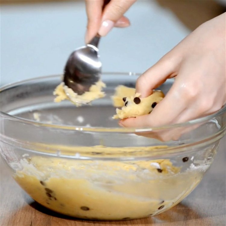 Image of Weigh 50g of cookie dough or pipe onto a baking...