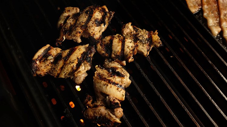 Image of Begin to grill the chicken thighs on the GrillGrates, directly...