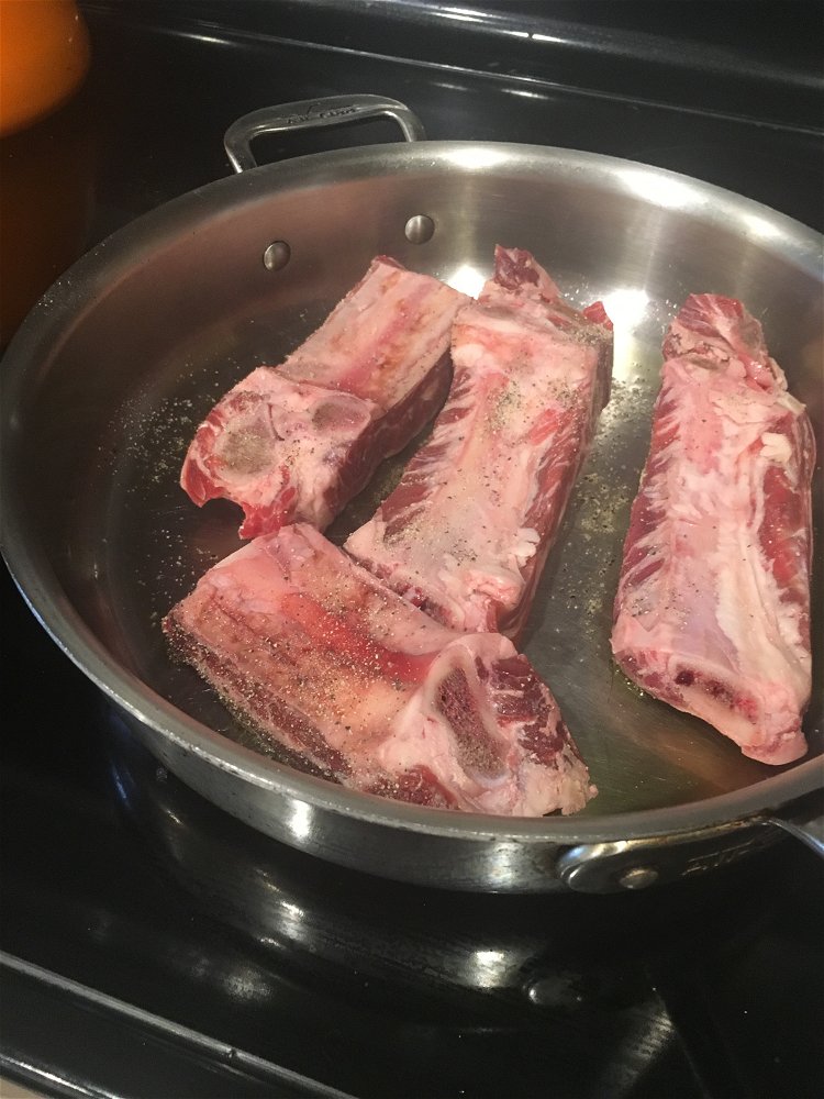 Image of Add half of the seasoned ribs to the hot skillet....