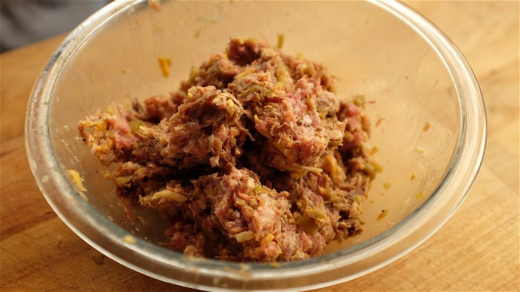 Image of Combine the raw smoked sausage, pulled pork, smoked cheddar and...