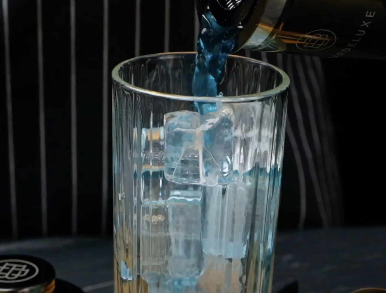 Image of Der Drink wird in ein mit Eiswürfeln gefülltes Glas gegeben.