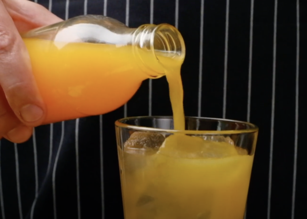 Image of Das Glas wird mit dem Orangensaft aufgefüllt.