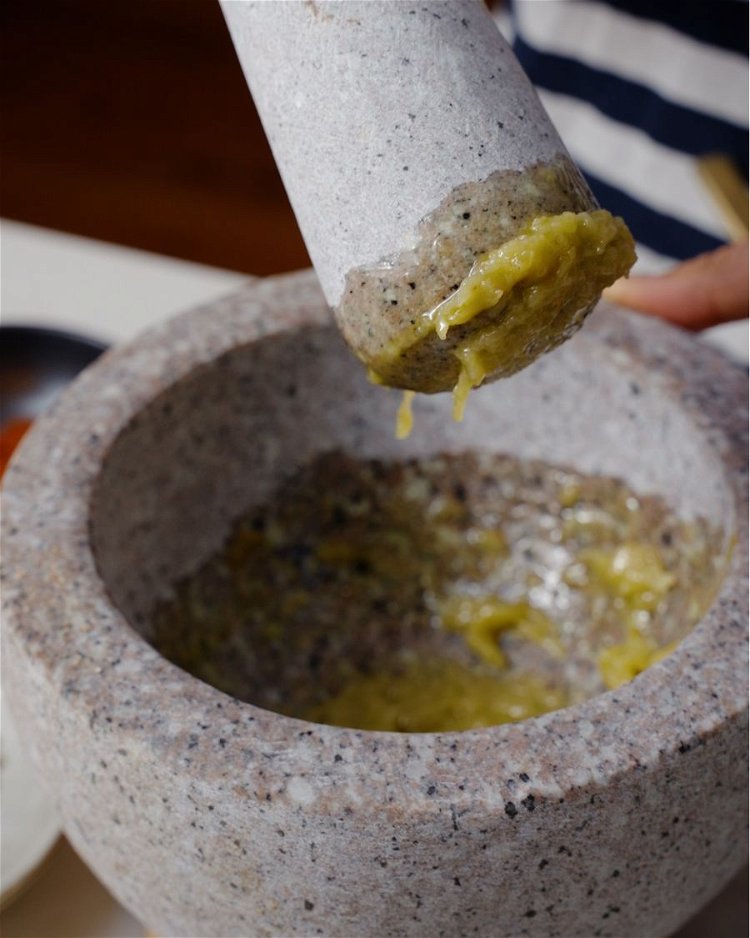 Image of Place 3 confit garlic cloves into the mortar with a...