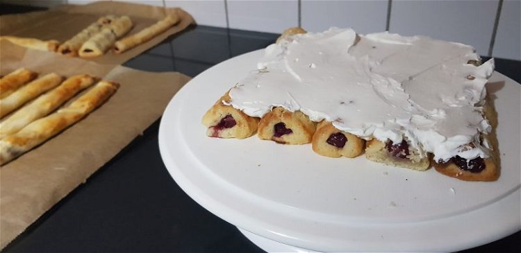 Image of 5 Kirschrollen nebeneinander legen und mit Creme bestreichen. 