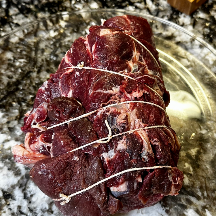 Image of Lay it flat on a cutting board or baking sheet and wrap three - five pieces of butcher's twine around the roast. This will help keep it together during the searing and cooking process.