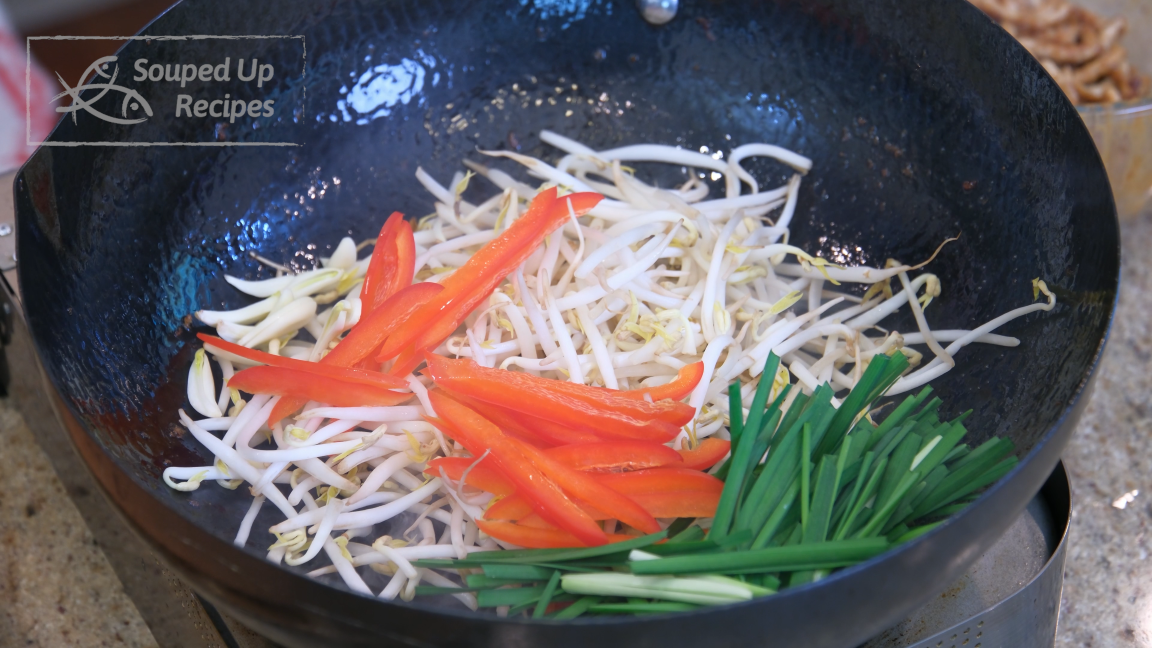 Image of Turn the heat high and toss the bean sprouts, garlic, red bell pepper, and garlic chives into the wok. Stir over high heat for a minute. Please don't overcook; otherwise, the bean sprouts will release liquid and lose the crunchy...