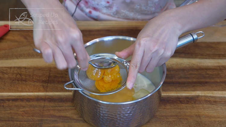 Image of Remove the salted egg yolk from the oven. Reserve 2 on the side and press the other 2 through a fine sieve into the saucepan. Once done, make sure you scrape the bottom of the sieve so you don't waste...